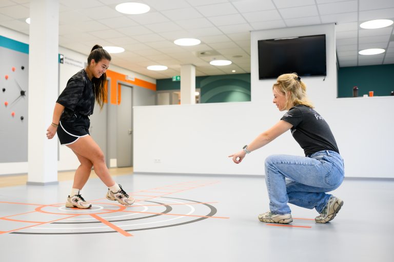 Fysiotherapeut begeleidt patiënt tijdens oefentherapie
